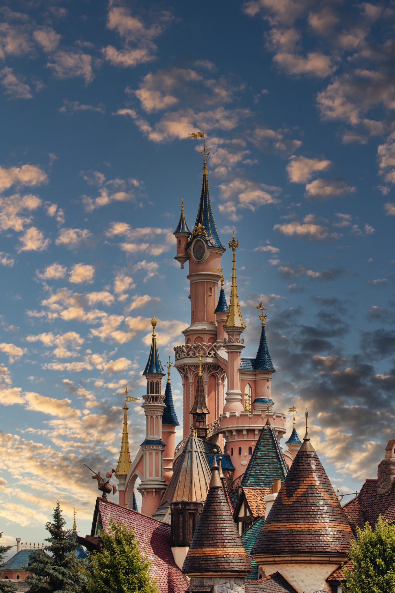 Pink Castle Towers Against Cloudy Blue Sky at Disneyland Paris, France.