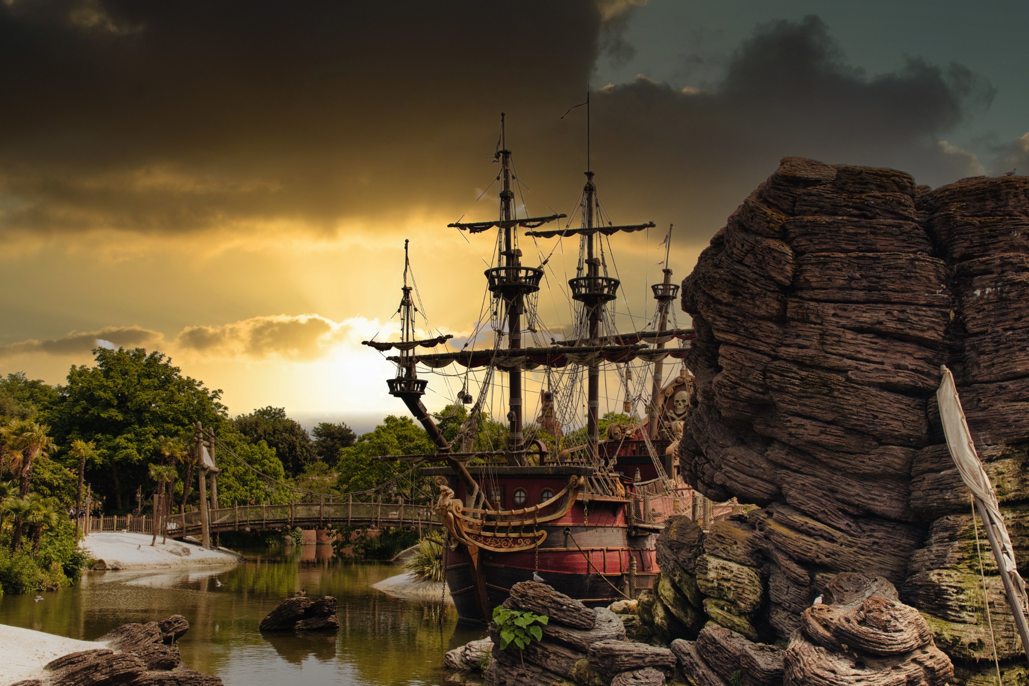 Tall Ship Moored Near Rocks and Bridge at Disneyland Paris, France.