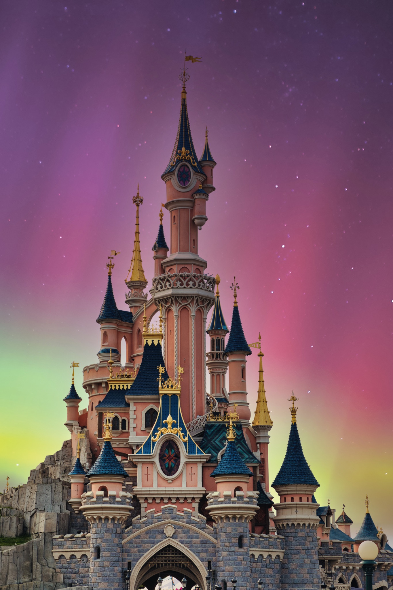 Pink Castle with Blue Turrets and Colorful Starry Sky at Disneyland Paris, France.