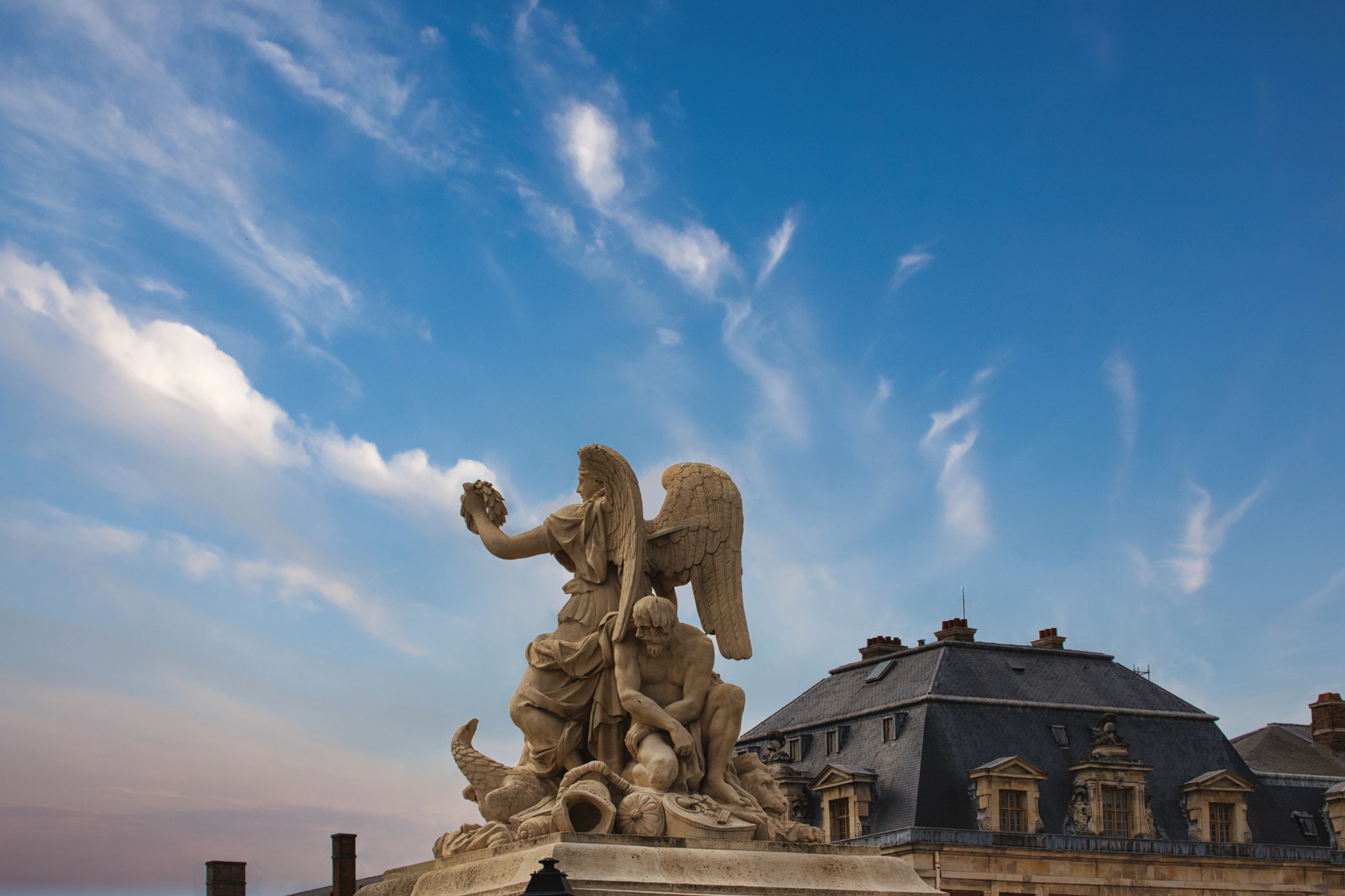 Sculpture of Winged Figure and Seated Man, Exterior at Versailles Gardens, Paris.